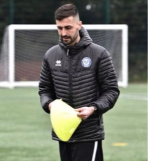 Coach Kamran Stead wearing a jacket on a football pitch